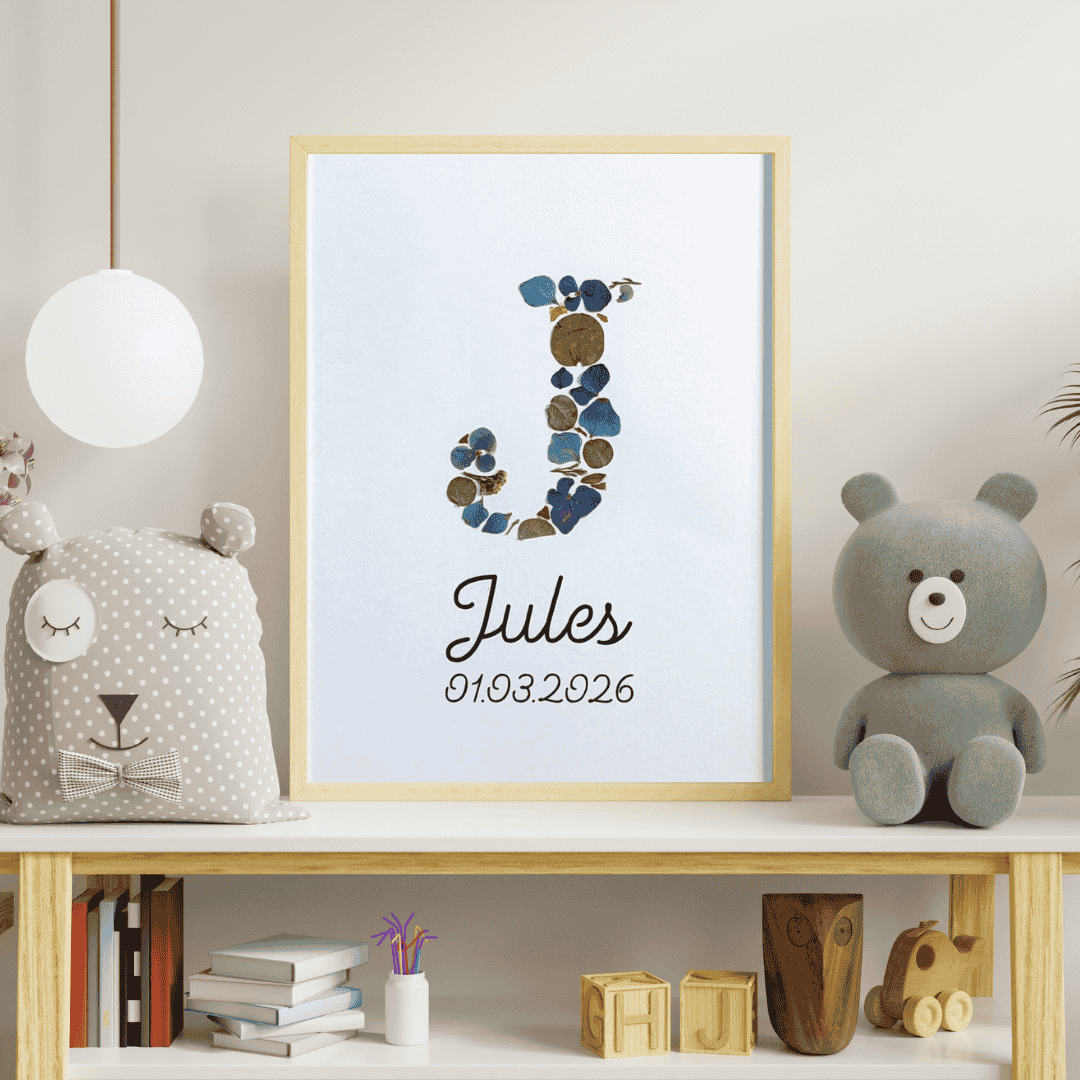 Cadeau personnalisé pour la naissance d'un bébé. Le cadre représente le monogramme de Jules en fleurs préssées avec son prénom et sa date de naissance personnalisé. Le cadre est joliment posée dans la chambre du bébé ou d'enfant en guise de décoration