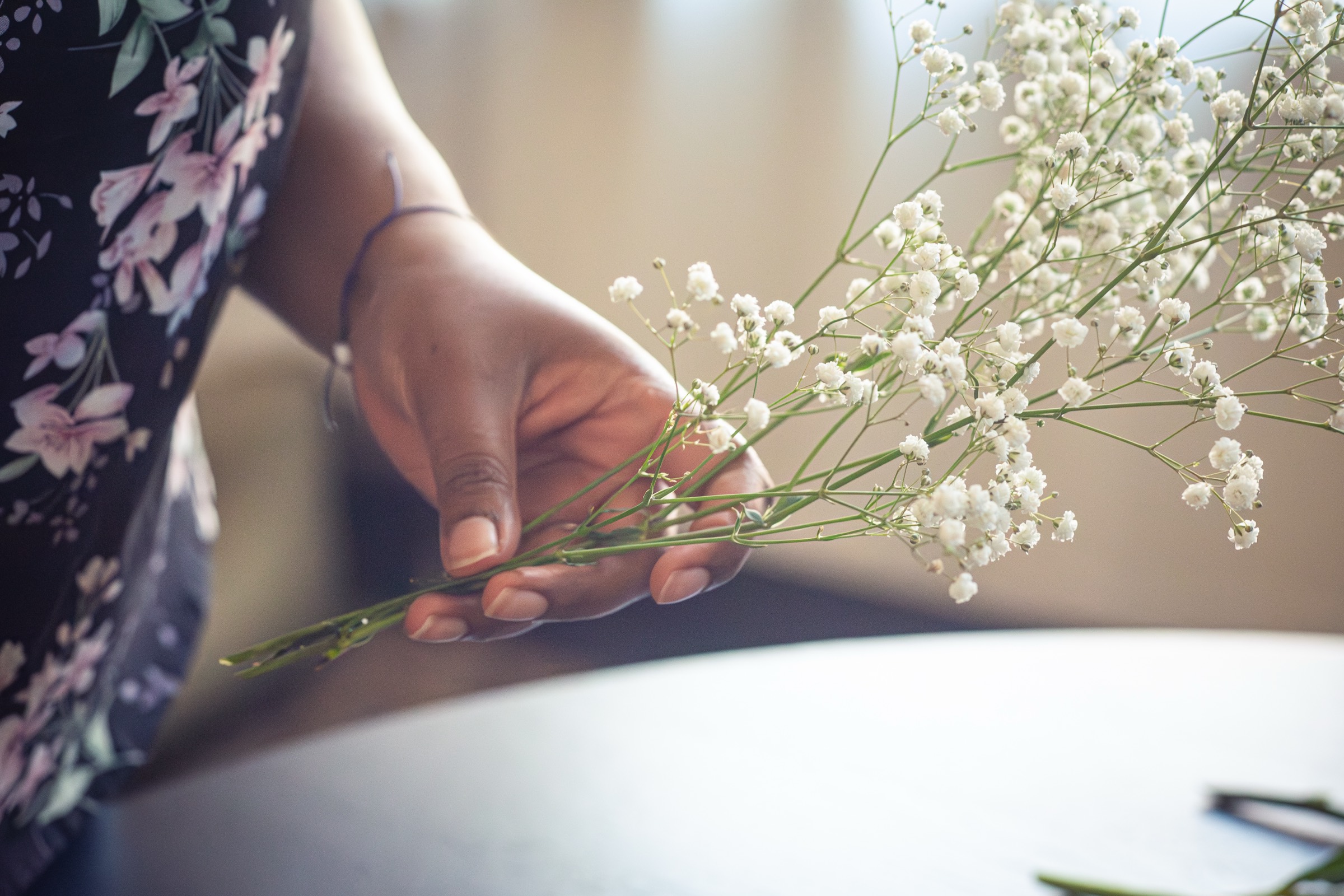 Mains tenant de la gypsophile pour la préparation d'un herbier de bouquet de mariage